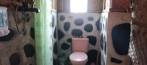 uma casa de banho com um WC rosa num quarto em Mysha Guest House-Lombok em Tetebatu