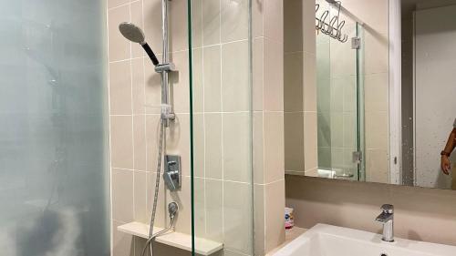 a shower with a glass door next to a sink at Hannah's Cottage at KL East The Ridge in Kuala Lumpur