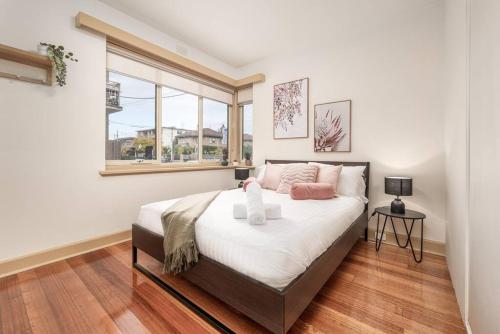a bedroom with a large bed and a window at Bright & Comfy 2 Bedroom St Kilda East Apartment in Melbourne