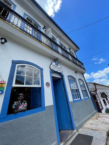 オウロ・プレットにあるCaminhos da Liberdade Pousadaの青いドアとバルコニー付きの建物