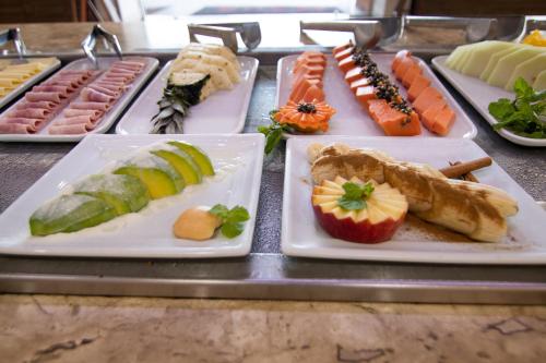 a buffet of different types of food on plates at Hotel Maua in Curitiba