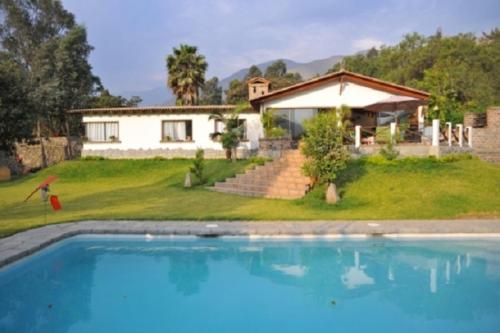 una casa con piscina frente a una casa en Casa El Palto, en Santa Eulalia