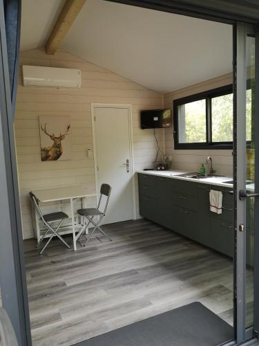 uma cozinha com mesa e cadeiras num quarto em Lodge avec terrasse em Charmeil
