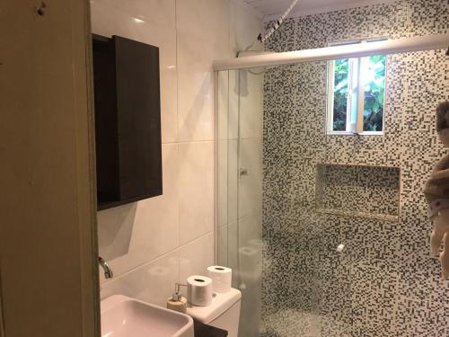 uma casa de banho com um chuveiro, um WC e um lavatório. em Casa agradável em Gramado em Gramado