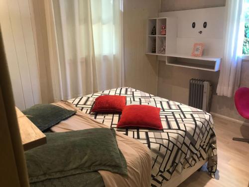 um quarto com 2 camas individuais e almofadas vermelhas em Casa agradável em Gramado em Gramado