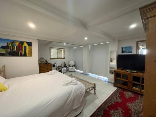 a bedroom with a large bed and a flat screen tv at Slice of Heaven at Number 7, privacy and views in Tweed Heads