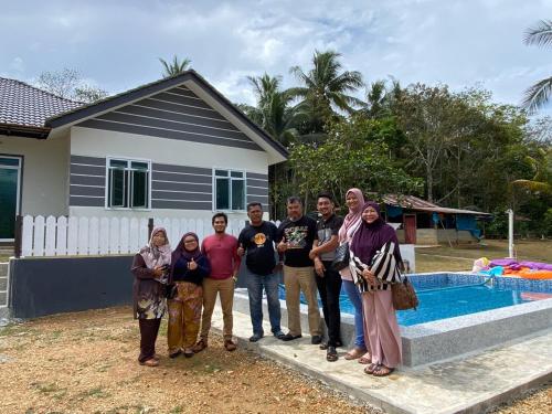 a group of people standing in front of a house at Homestay Bendang Hilir in Kuala Nerang