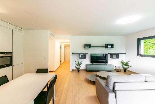 uma sala de estar com um sofá e uma mesa em 7 - Gioiello Moderno a Montagnola em Collina d'Oro