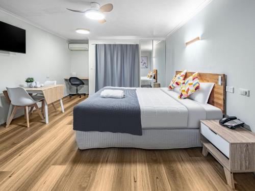 um quarto com uma cama king-size e uma secretária em Parkview Apartments em Brisbane