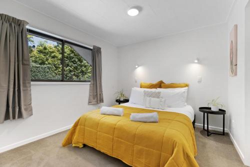 a bedroom with a large bed with a yellow blanket at Central town apartment in Queenstown