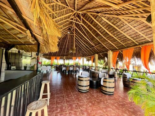 een restaurant met een bar met stoelen en een plafond bij Hotel Rincon Rubi in Las Galeras