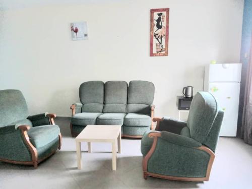 a living room with three chairs and a couch and a table at Résidence Marie France MENDY in Toubab Dialaw