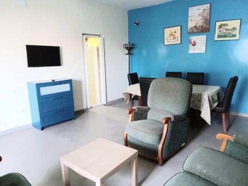 a living room with a couch and chairs and a tv at Résidence Marie France MENDY in Toubab Dialaw