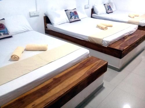 Habitación con 2 camas de madera en White House Udawalawe, en Udawalawe