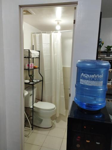 uma casa de banho com WC e um balde azul em Staycation 2 Bedroom in Urban Deca Home Marilao em Marilao