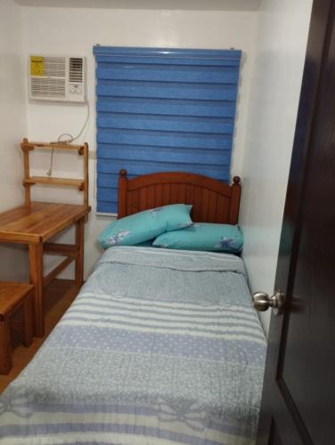um quarto com uma cama com uma cabeceira azul em Staycation 2 Bedroom in Urban Deca Home Marilao em Marilao
