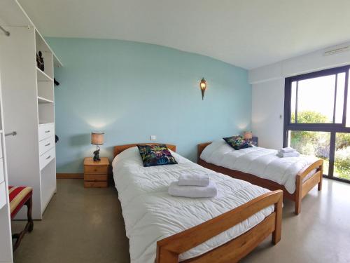 une chambre avec deux lits et une fenêtre dans l'établissement Villa in Locquirec with Stunning Sea Views, à Locquirec