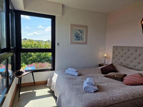 une chambre avec un lit et une grande fenêtre dans l'établissement Villa in Locquirec with Stunning Sea Views, à Locquirec