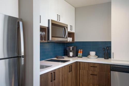 a kitchen with a sink and a microwave at Staybridge Suites Rochester - Mayo Clinic Area by IHG in Rochester