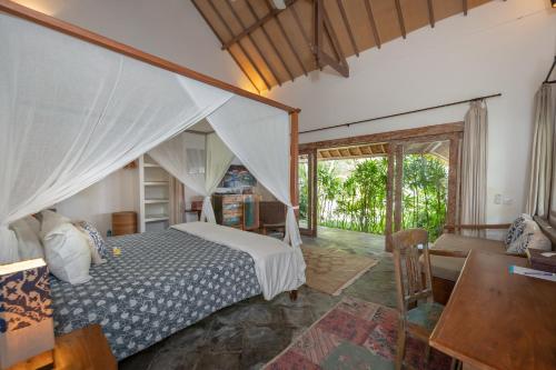 a bedroom with a bed and a living room at Villa Damai Manis in Seminyak