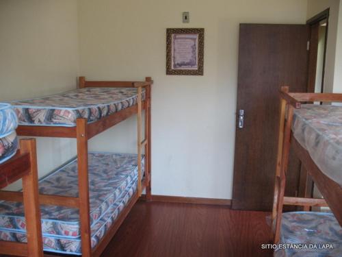 a room with two bunk beds and a door at SITIO ESTANCIA DA LAPA in Sao Jose da Lapa