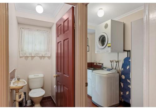 a bathroom with a toilet and a sink and a microwave at Discovery Parks - Burrill Lake, Ulladulla in Burrill Lake