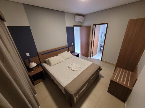 a bedroom with a large bed and a window at Apartamento 2 quartos no Alta Vista Thermas Resort in Caldas Novas