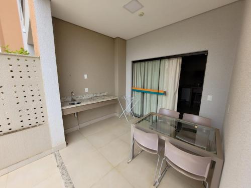a dining room with a glass table and chairs at Apartamento 2 quartos no Alta Vista Thermas Resort in Caldas Novas