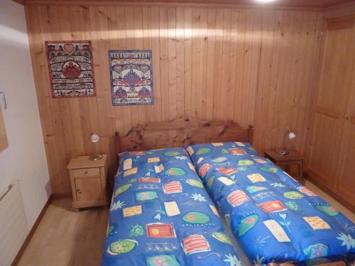 a bedroom with a bed with a blue comforter at Chalet Aebnetbode in Gstaad