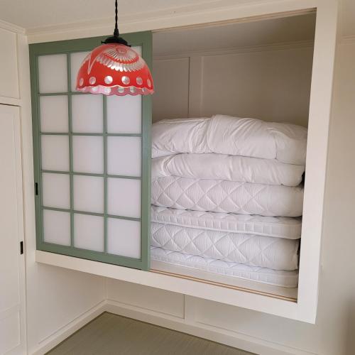 a closet with a stack of white towels at Biei Central Villa - Green Garden in Biei