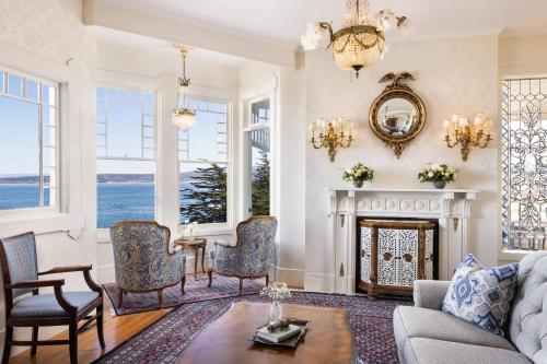 a living room with a fireplace and a chandelier at Seven Gables Inn on Monterey Bay, A Kirkwood Collection Hotel in Pacific Grove