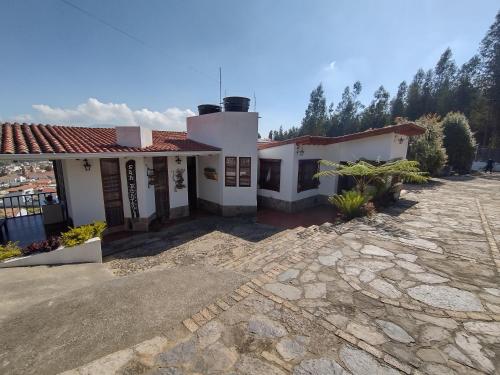 a house with a stone driveway in front of it at San Benito Hotel in Tibasosa