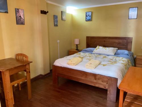 a bedroom with a bed with two towels on it at La Casa de Zarela in Huaraz