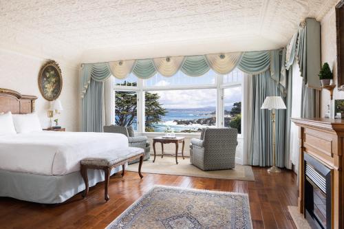a bedroom with a bed and a large window at Seven Gables Inn on Monterey Bay, A Kirkwood Collection Hotel in Pacific Grove