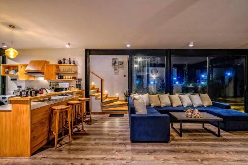 uma sala de estar com um sofá azul e uma cozinha em Dream Cottage Nuwara Eliya em Nuwara Eliya