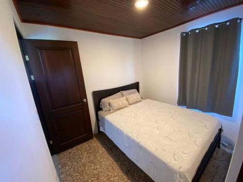 a small bedroom with a bed and a window at Retana Apartment in Quesada