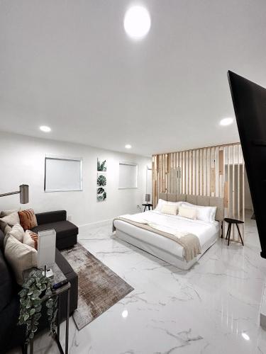 a bedroom with a large bed and a couch at NEW Comfy and Modern House near Miami Airport in Miami