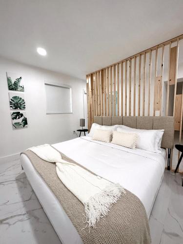 a bedroom with a large bed with white sheets at NEW Comfy and Modern House near Miami Airport in Miami