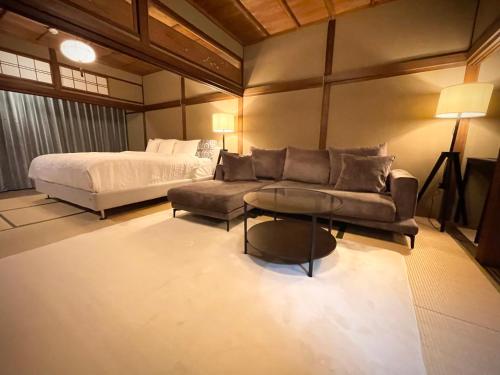 1 dormitorio con cama, sofá y mesa en Machiya no Yado Gu en Nara