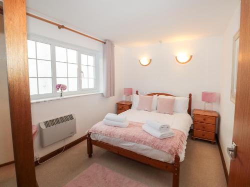 una camera da letto con un letto con due asciugamani sopra di Primrose Cottage a Paignton