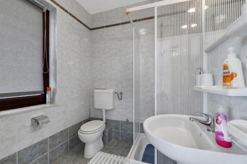 a bathroom with a toilet and a sink and a shower at Room 79-2 in Duće
