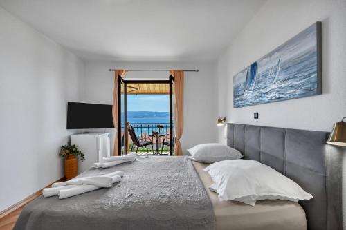 a bedroom with a large bed and a balcony at Room 79-3 in Duće
