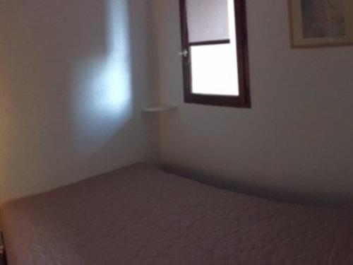 une petite chambre avec un lit et une fenêtre dans l'établissement Appartement T2 climatisé avec piscine et parking à Port Barcarès - FR-1-81-402, au Barcarès