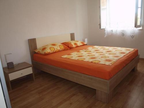 a bedroom with a bed with orange sheets and a window at Apartment in Slatine with sea view, balcony, air conditioning, Wi-Fi (4784-2) in Slatine