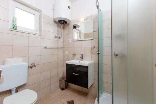 a bathroom with a toilet and a sink and a shower at Apartment in Slatine with sea view, balcony, air conditioning, Wi-Fi (4784-2) in Slatine