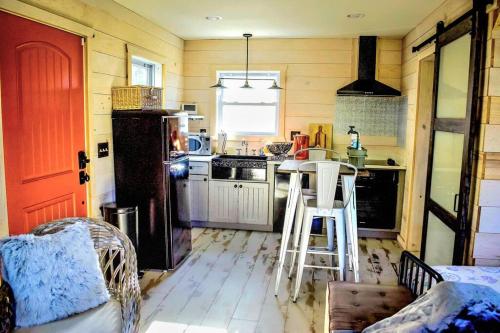 a kitchen with a refrigerator and a table in it at Secluded Tiny House by the Marsh with Hunting Island Beach Pass in St. Helena Island