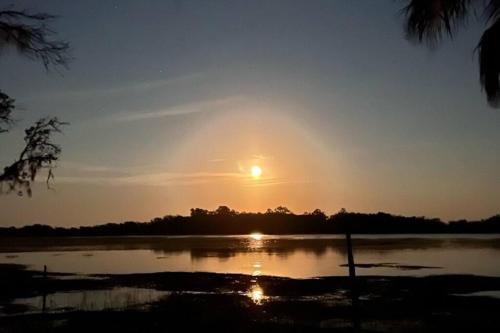 a sunset over a lake with the sun in the sky at Secluded Tiny House by the Marsh with Hunting Island Beach Pass in St. Helena Island