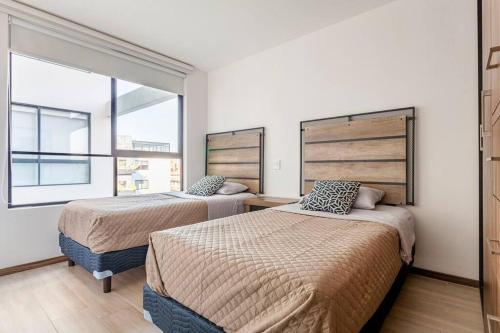 2 camas en una habitación con ventana en Depto excelente ubicación en Narvarte, en Ciudad de México