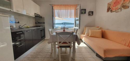 a kitchen and dining room with a table and a couch at Apartment in Sevid with Seaview, Terrace, WIFI (4746-2) in Sevid