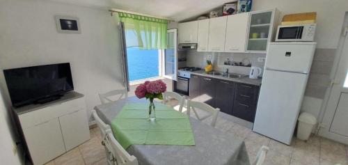 a kitchen with a table with a vase of flowers on it at Apartment in Sevid with Seaview, Terrace, WIFI (4746-1) in Sevid